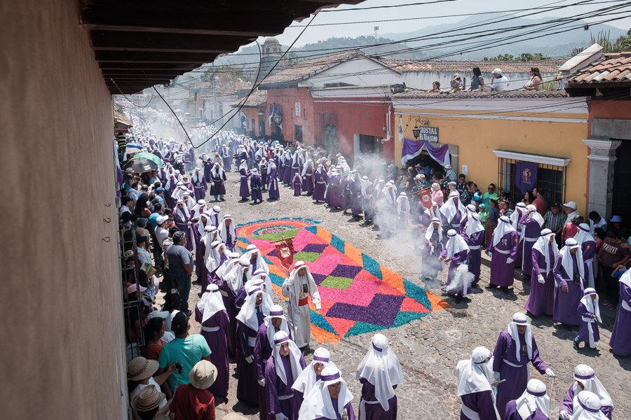 Purple cloaks fill the street and silence the crowd as the formal procession approaches.
