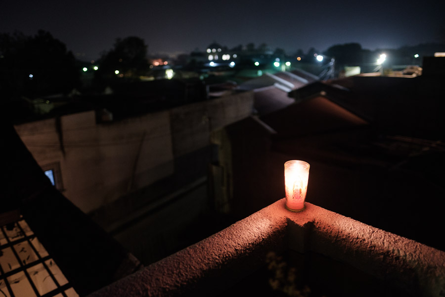 Away from the action, a candle bearing the image of Guadalupe is lit on a rooftop terrace, overlooking the distant lights and din that is Antigua during Holy Week.