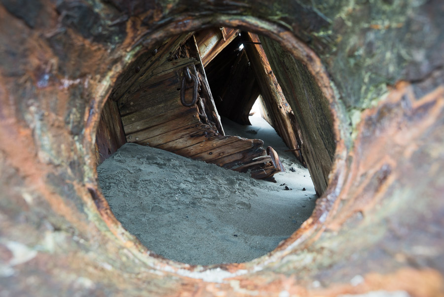 Looking through the porthole of the Pesuta shipwreck. Sunk in a winter storm crossing the Hecate Strait in 1928, it has come to rest here on East Beach.