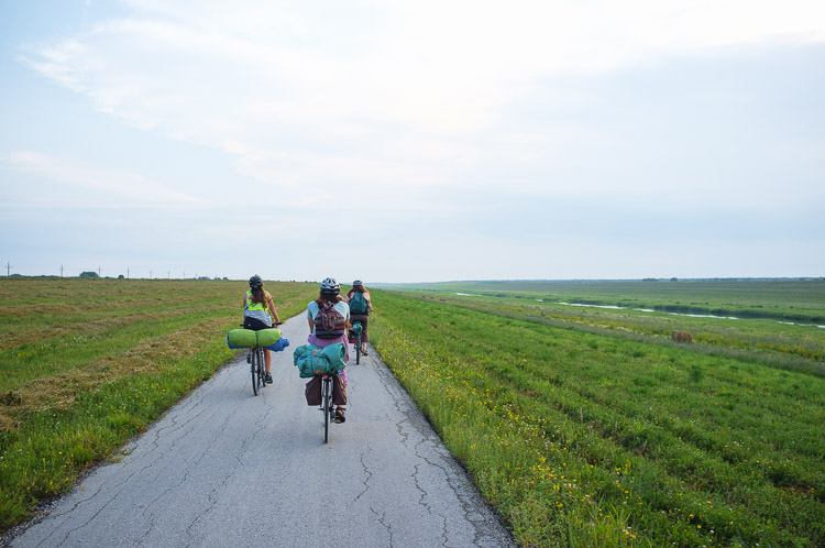 Cyclists leave the city limits and cross prairie fields to be the first to arrive at the festival site.